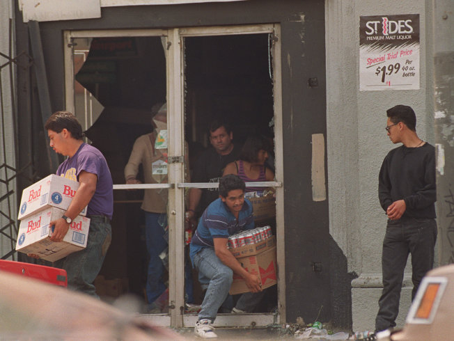 Looters leave a liquor store with cases of beer on May 1,1992, in Los Angeles.